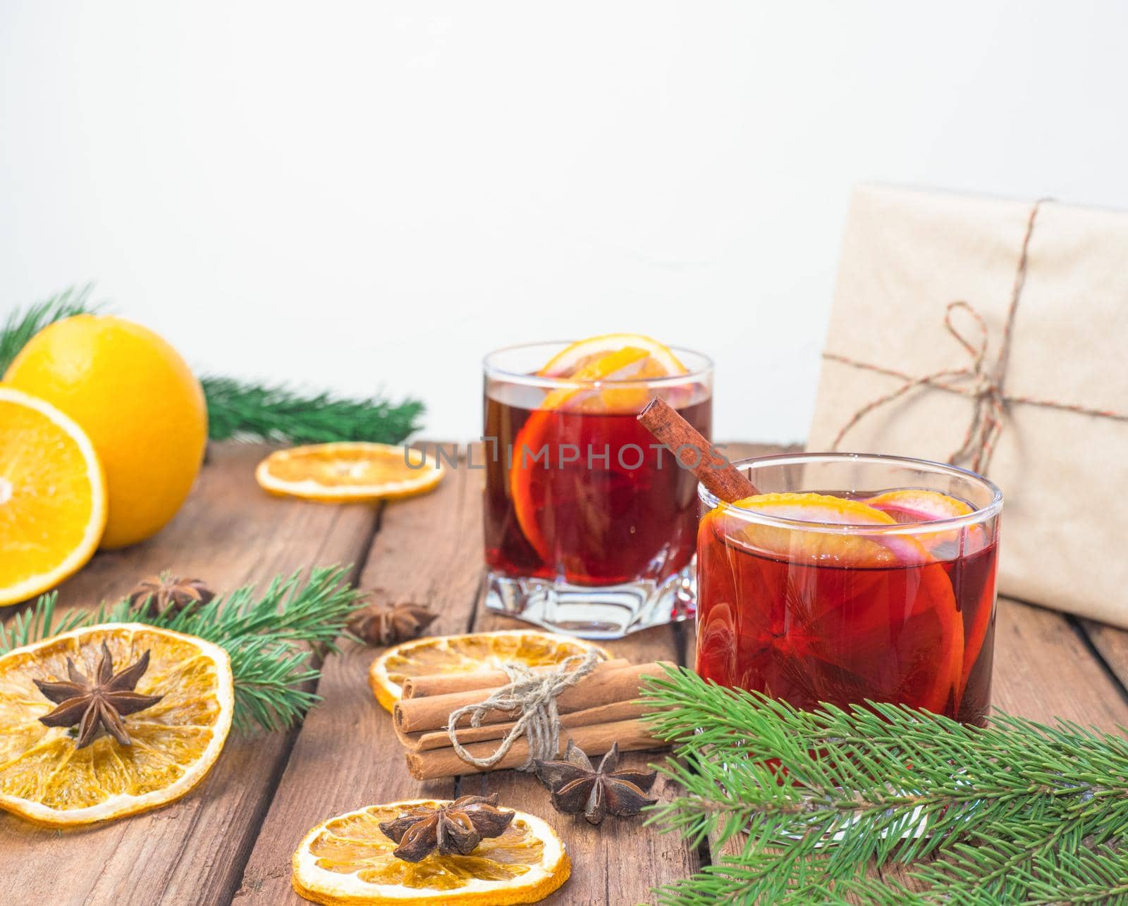 Christmas mulled red wine with spices and fruits on a wooden rustic table. Traditional hot drink at Christmas time by Ekaterina34