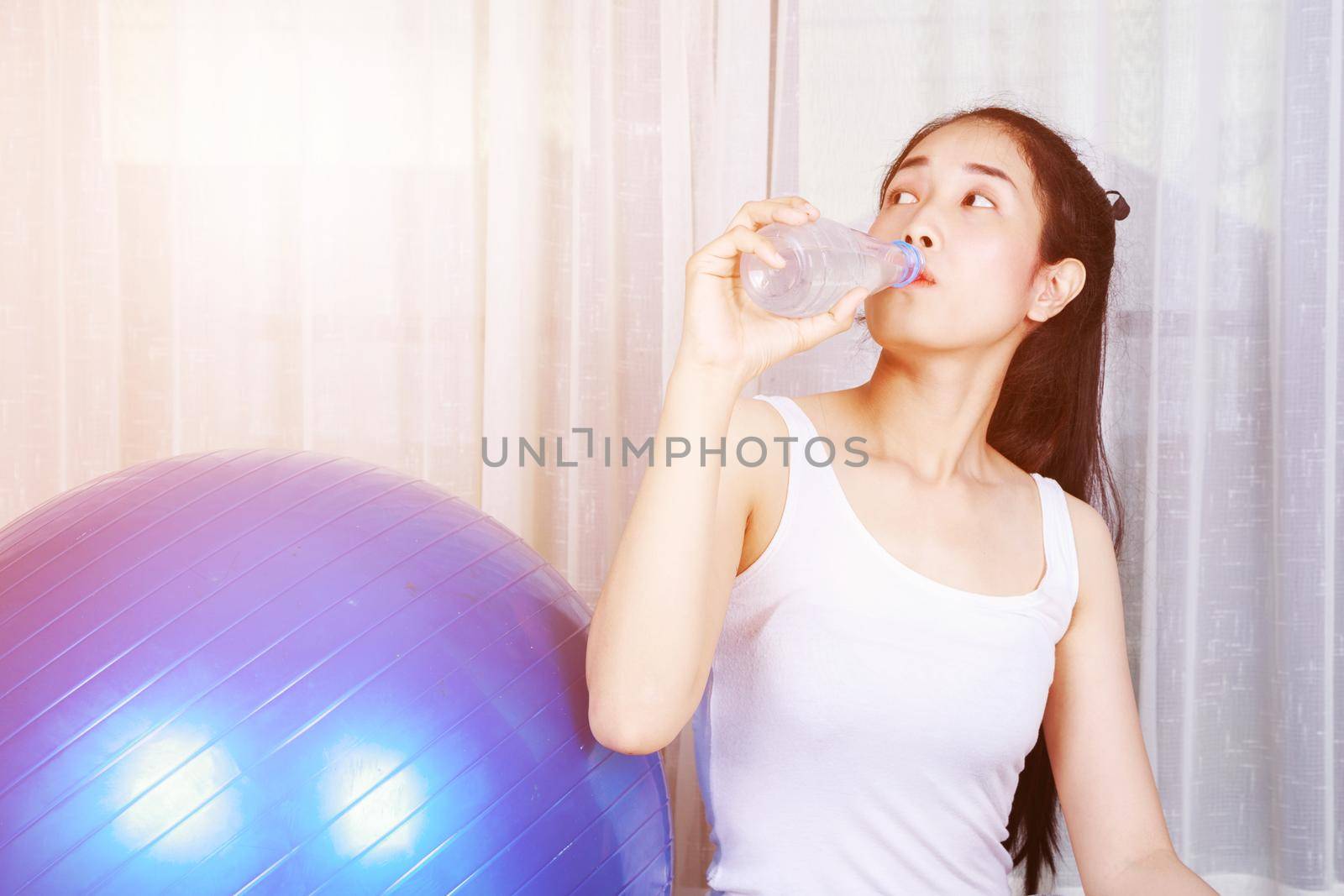 woman drinking water after  exercise with fitness ball by geargodz