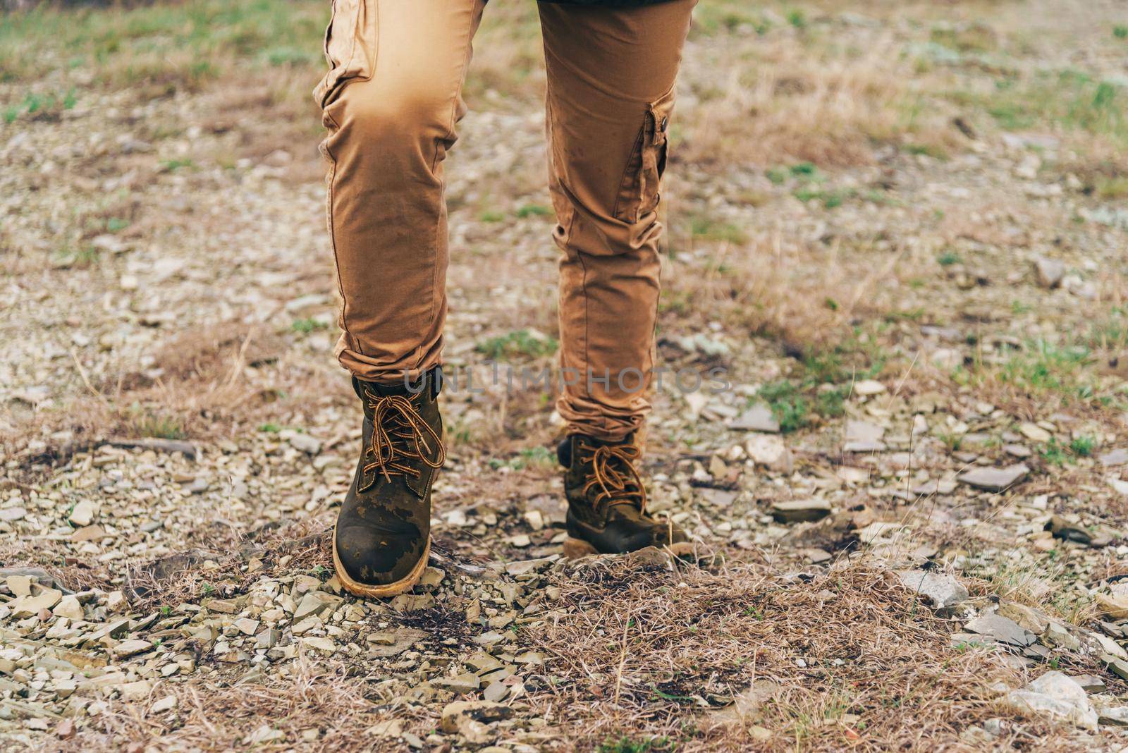 Hiker walking up on mountain at rainy weather. View of legs