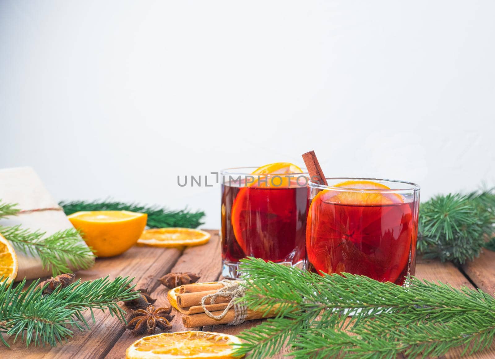 Christmas mulled wine on a wooden background with spices and spruce branches and dried orange. by Ekaterina34