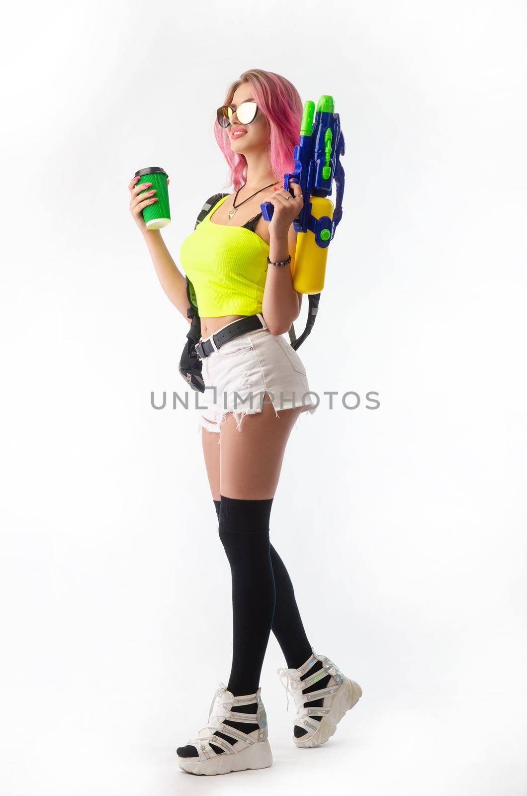 a girl with a water gun in summer clothes, slim and sexy, isolated on a white background drinking coffee