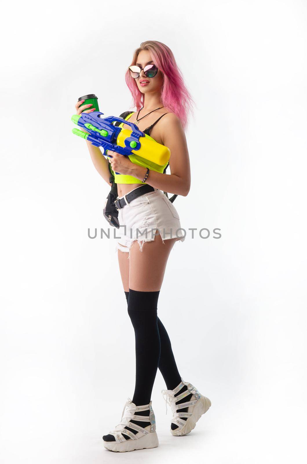 a girl with a water gun in summer clothes, slim and sexy, isolated on a white background drinking coffee