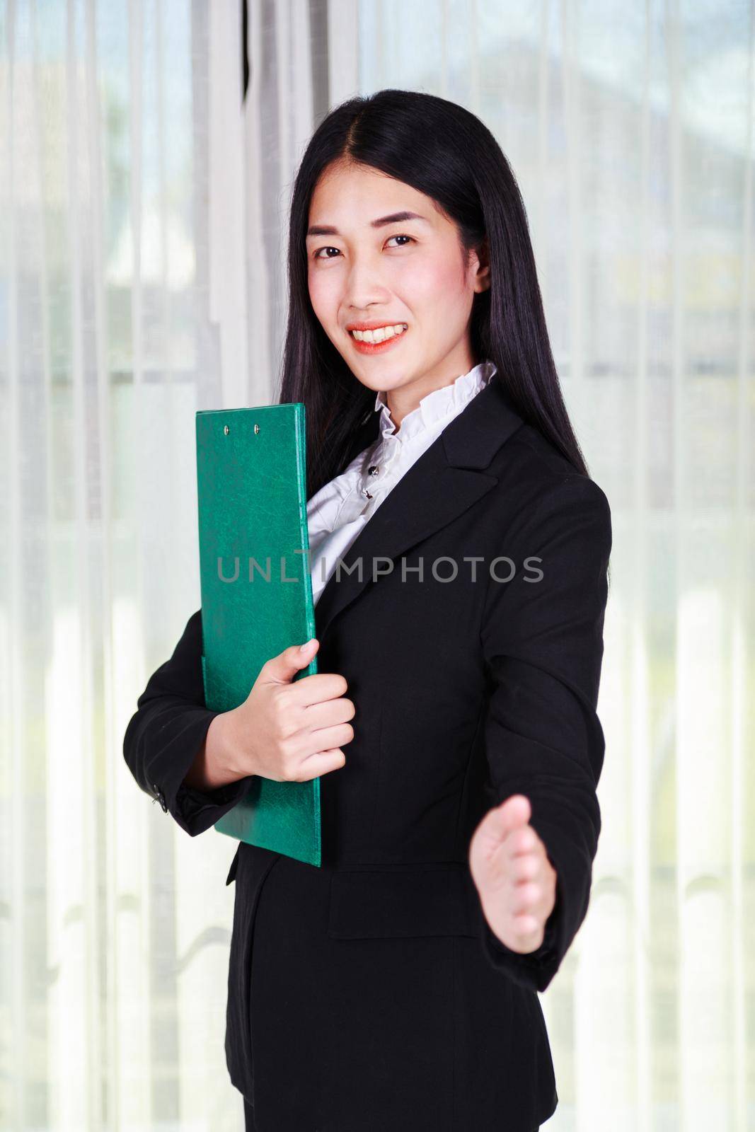 young business woman holding a clipboard and gives a handshake