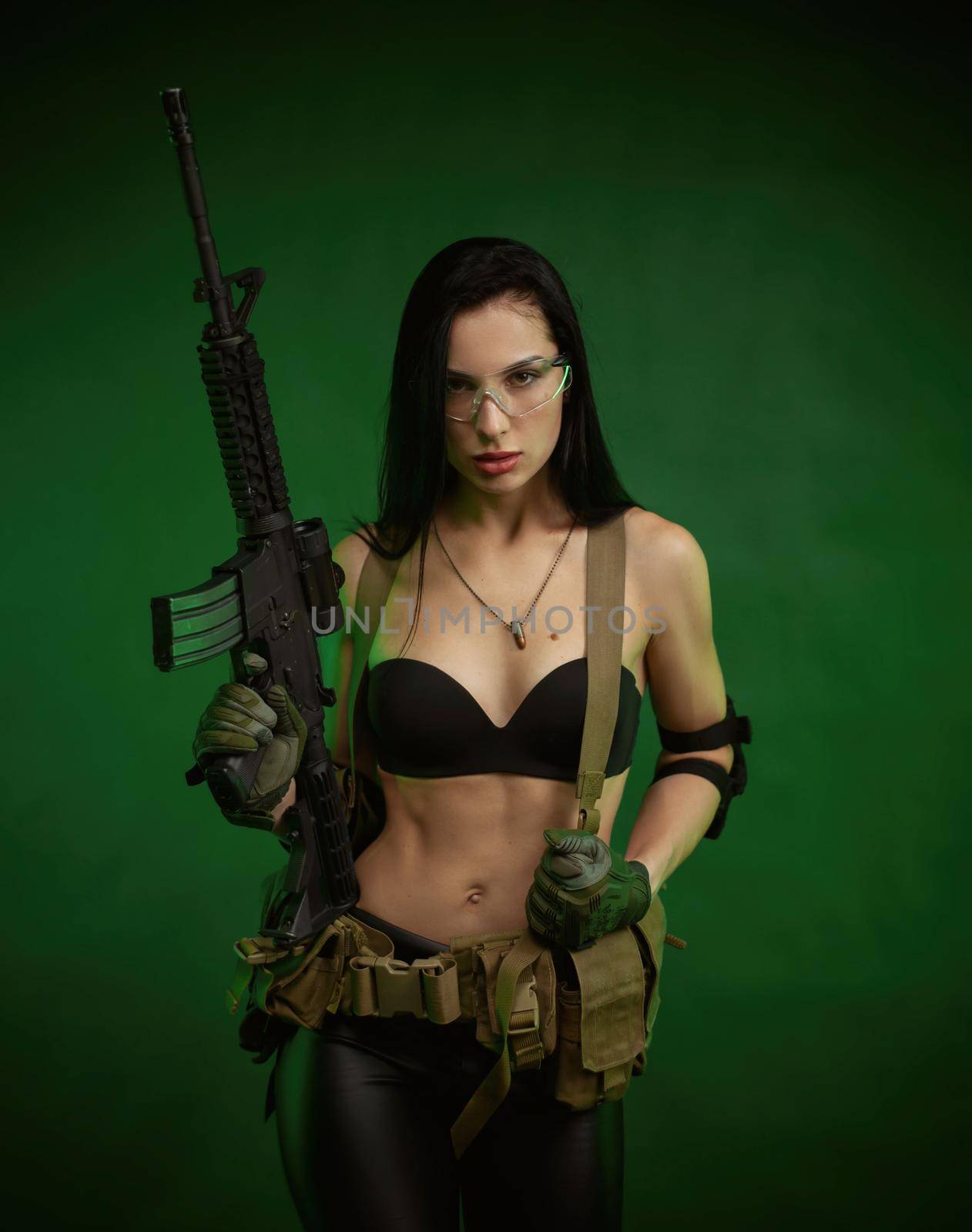 the slender woman in military fatigues with an American automatic rifle on a green background