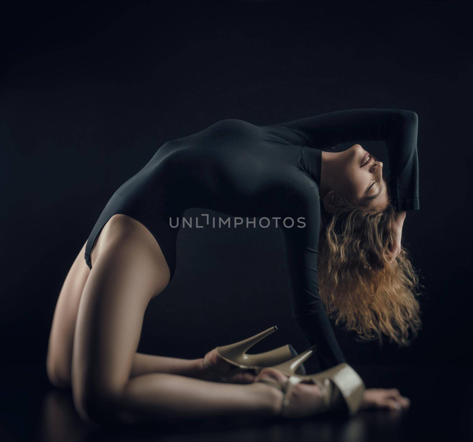 the flexible sexy girl poses on a black background in the fitting clothes (baud)