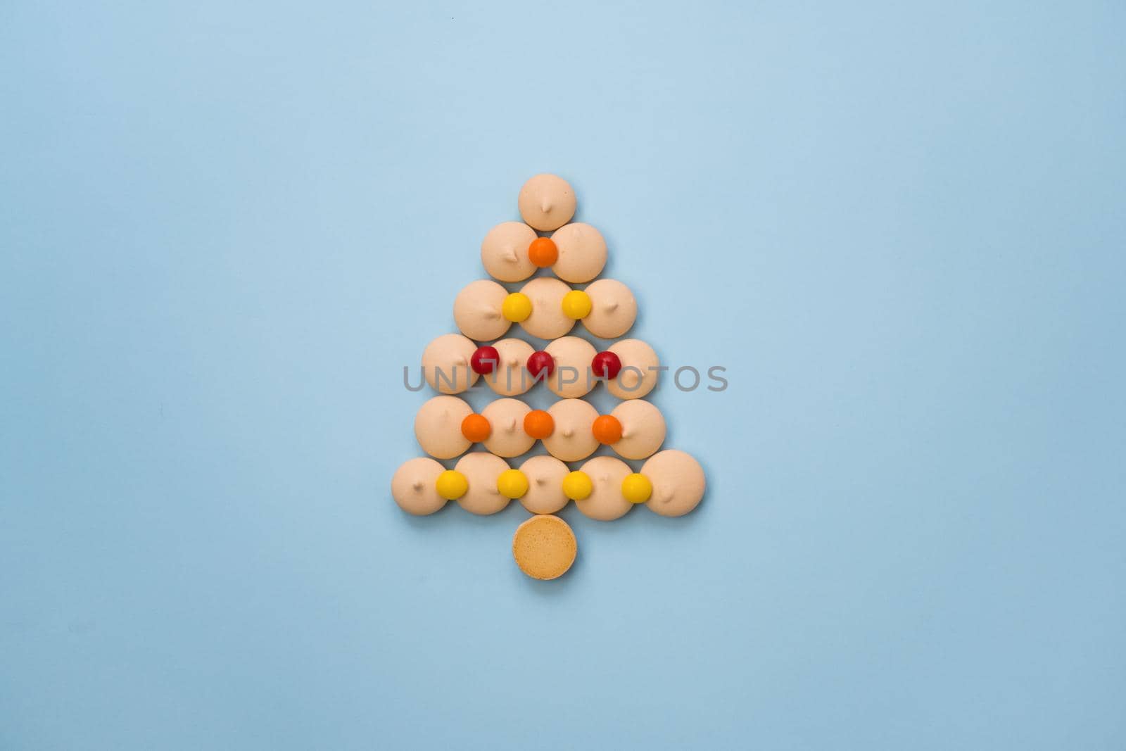 Christmas tree made of cookies and sweets on a blue background with space for text. Christmas baking concept