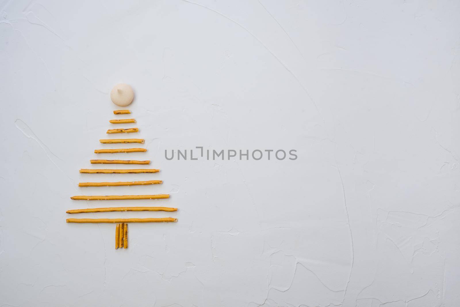 Christmas tree made from pepero straws cookies, on white background texture. Top view with space for text on the right by Ekaterina34