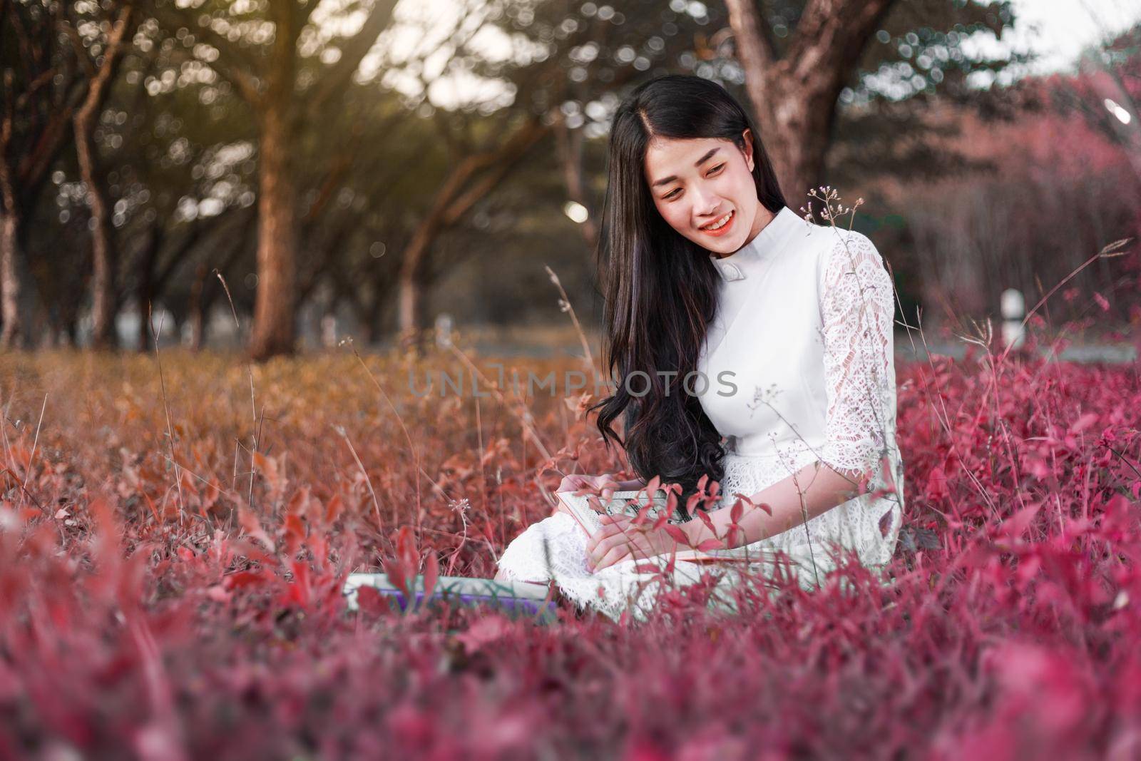 young woman reading a book in the park