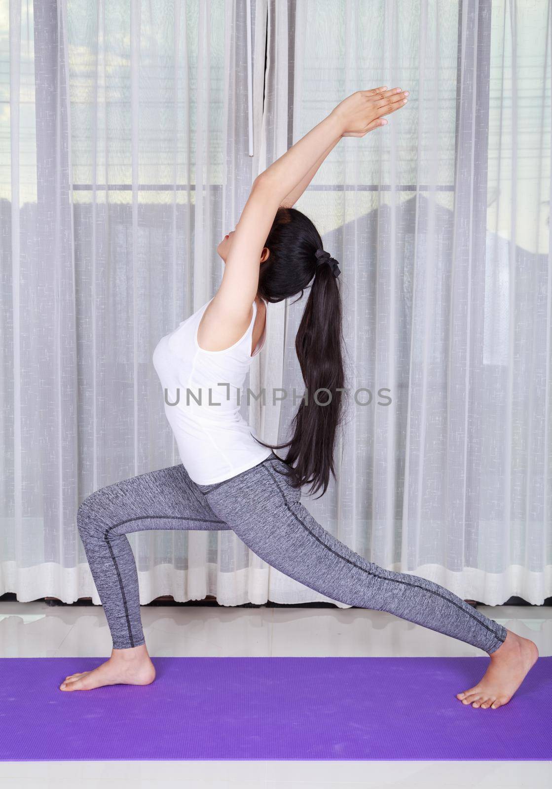 young woman doing yoga exercise isolated on a white background