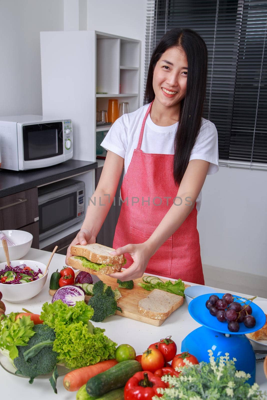 woman preparing a sandwich in kitchen room at home