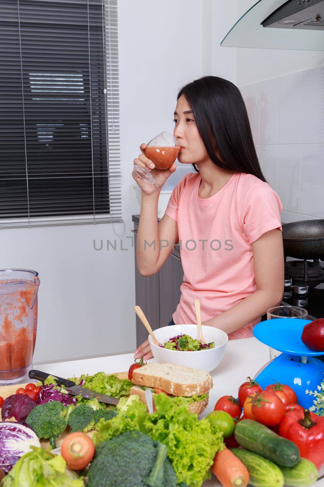 woman with smoothies in glass at kitchen room by geargodz