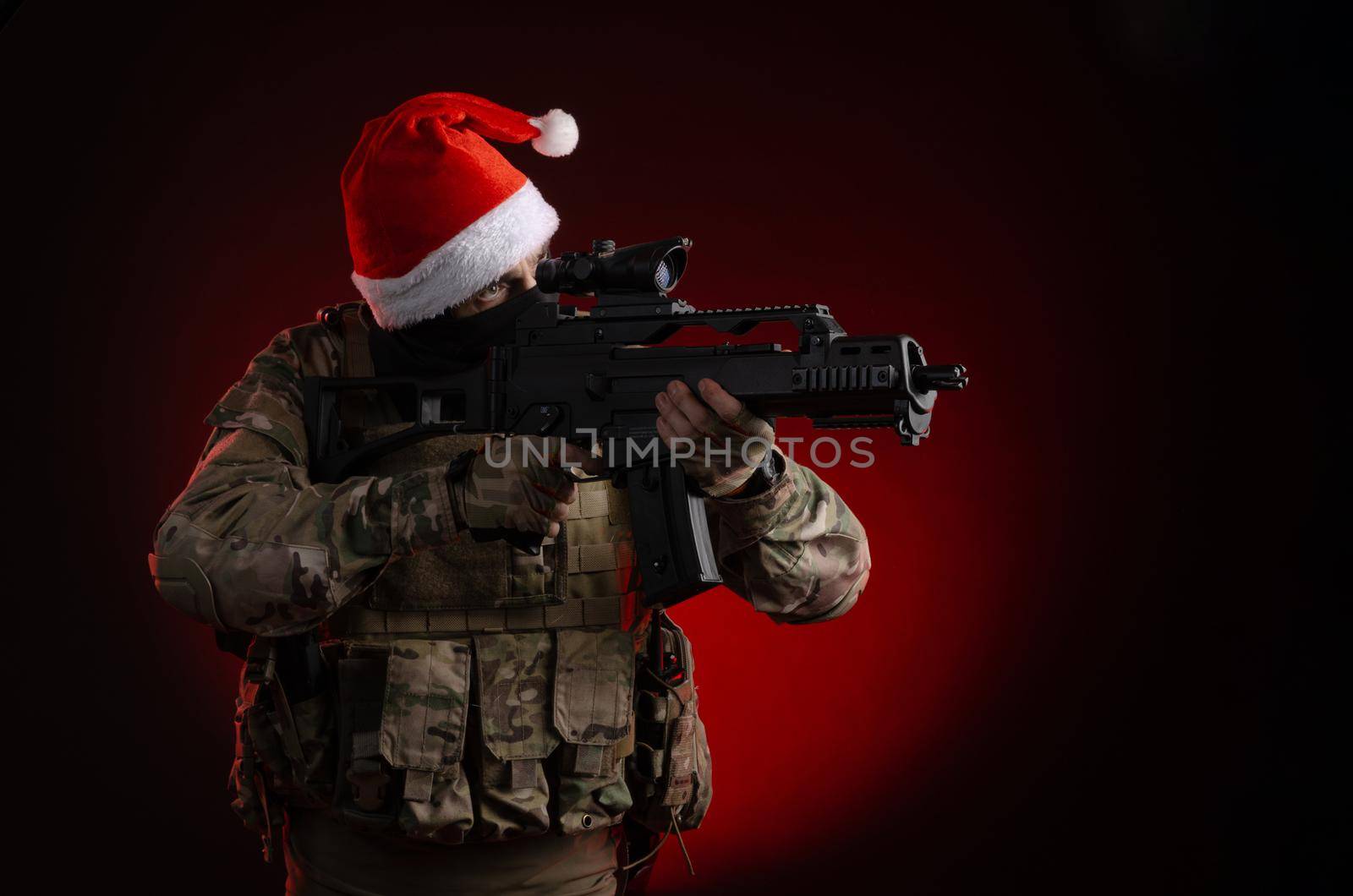 the man in a military uniform with a gun and a Santa Claus hat