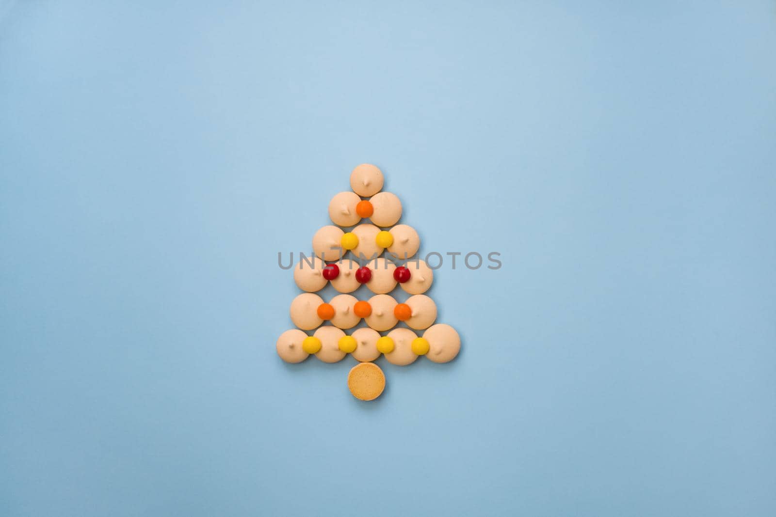 Christmas tree made of cookies and sweets on a blue background with space for text. Christmas baking concept