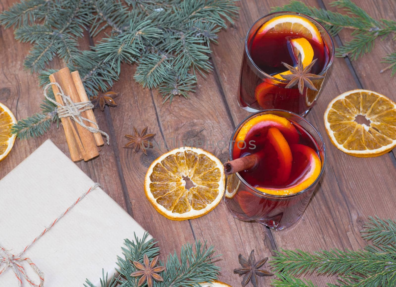 Christmas mulled red wine with spices and fruits on a wooden rustic table. Traditional hot drink at Christmas time by Ekaterina34