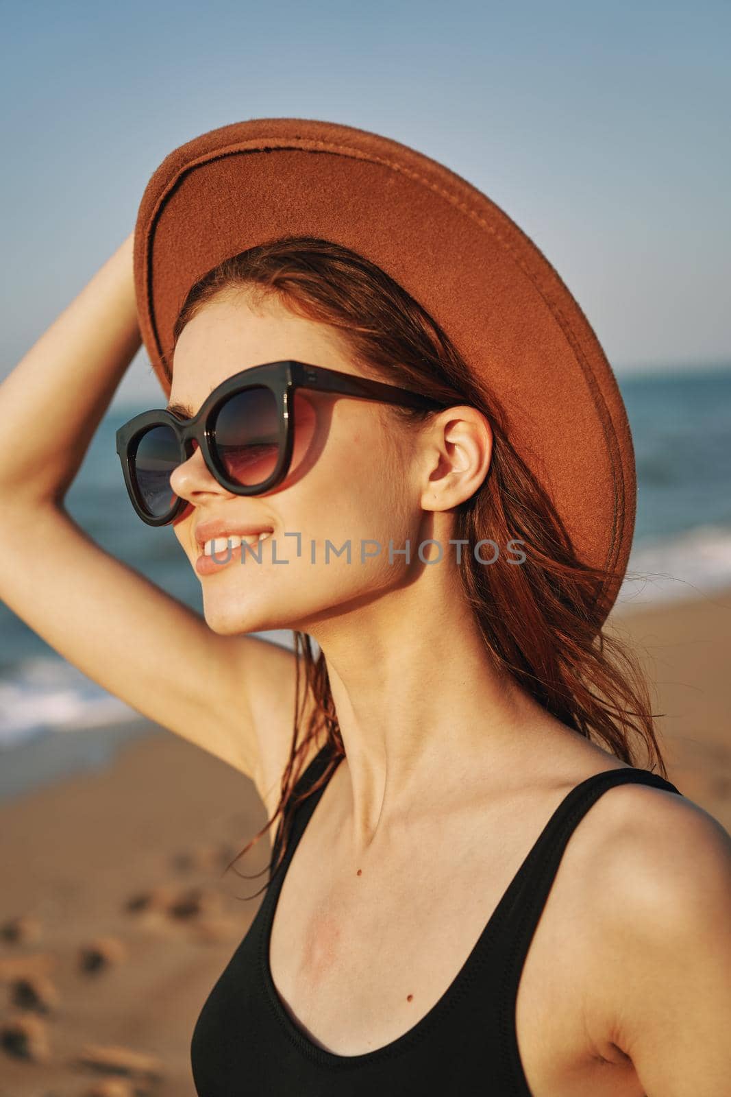 cheerful woman in sunglasses Sandy coast landscape sun. High quality photo