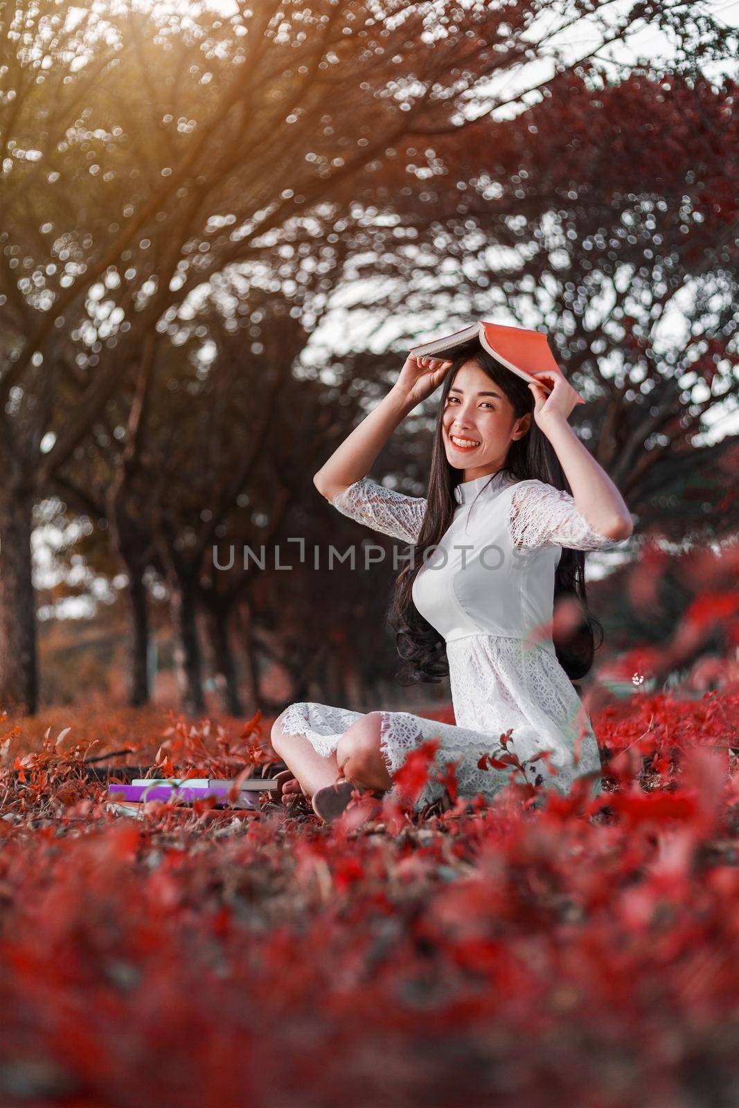 young woman holding a book in park by geargodz