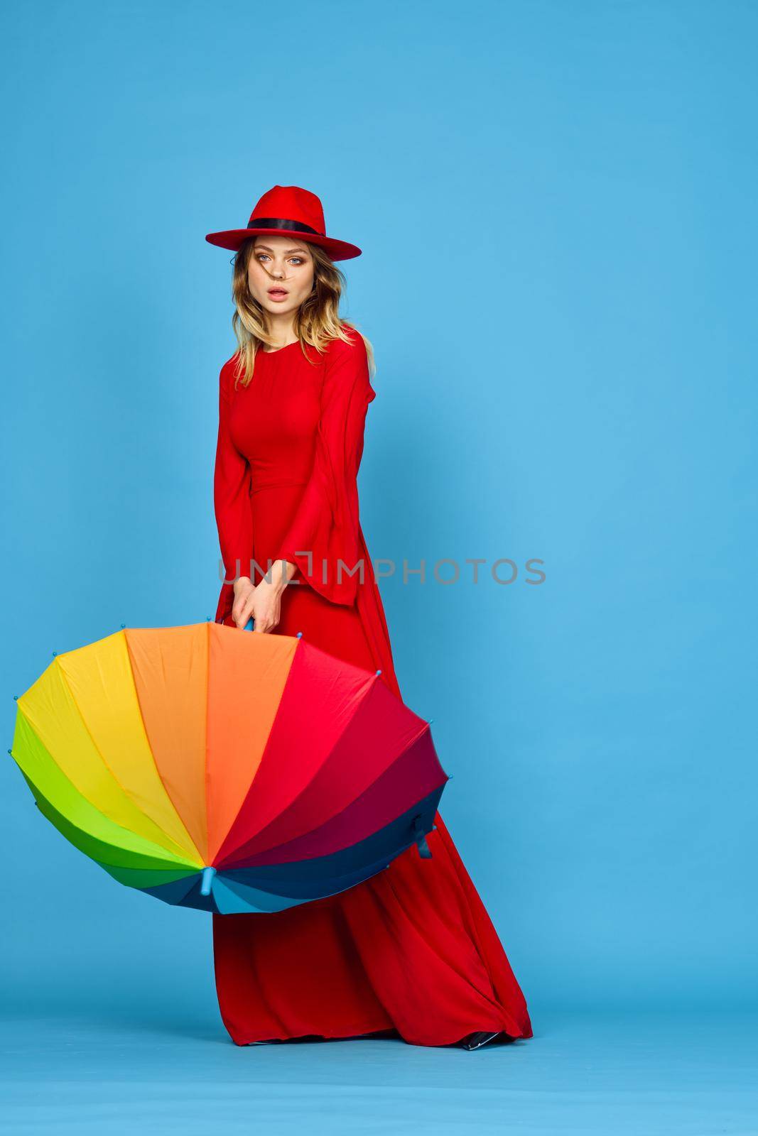 woman in red dress multicolored umbrella blue background by Vichizh