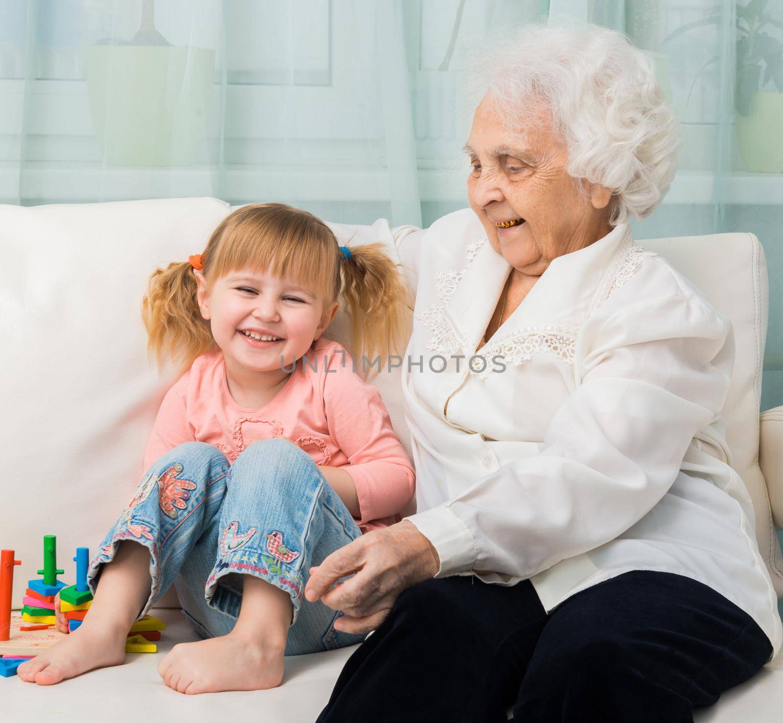 little girl with grandmother on a sofa by tan4ikk1