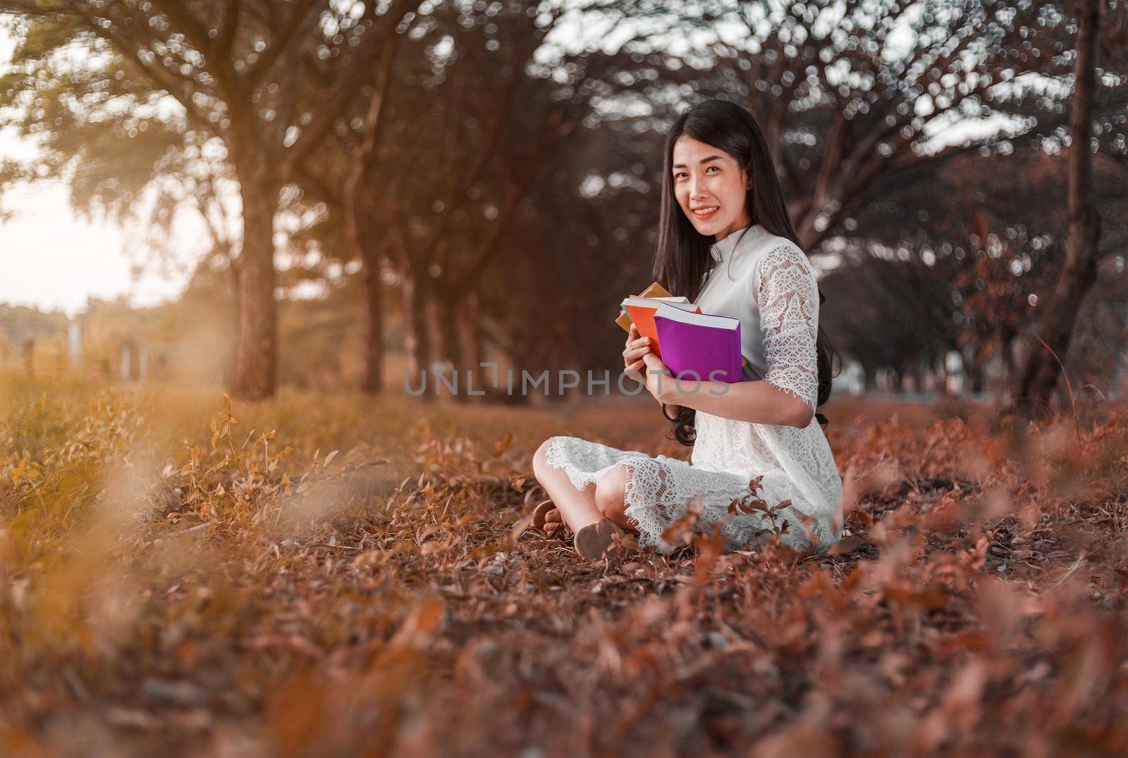 young woman holding a book in the park