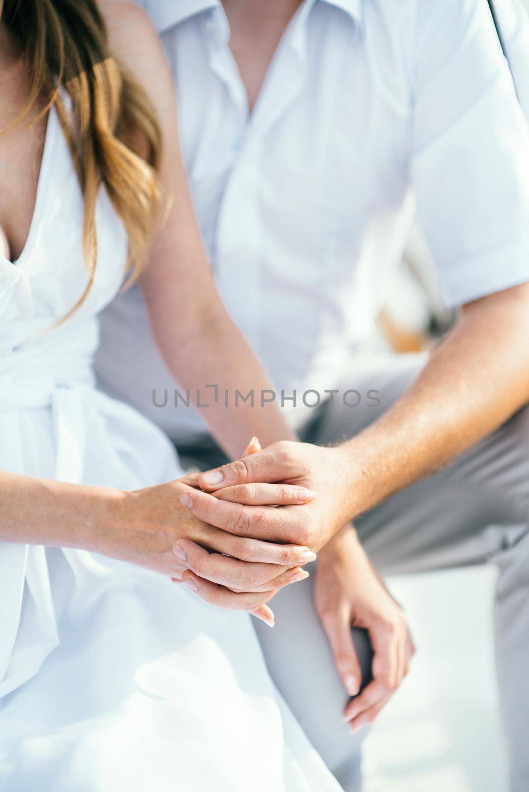 the bride and groom tenderly hold hands between them love and relationships