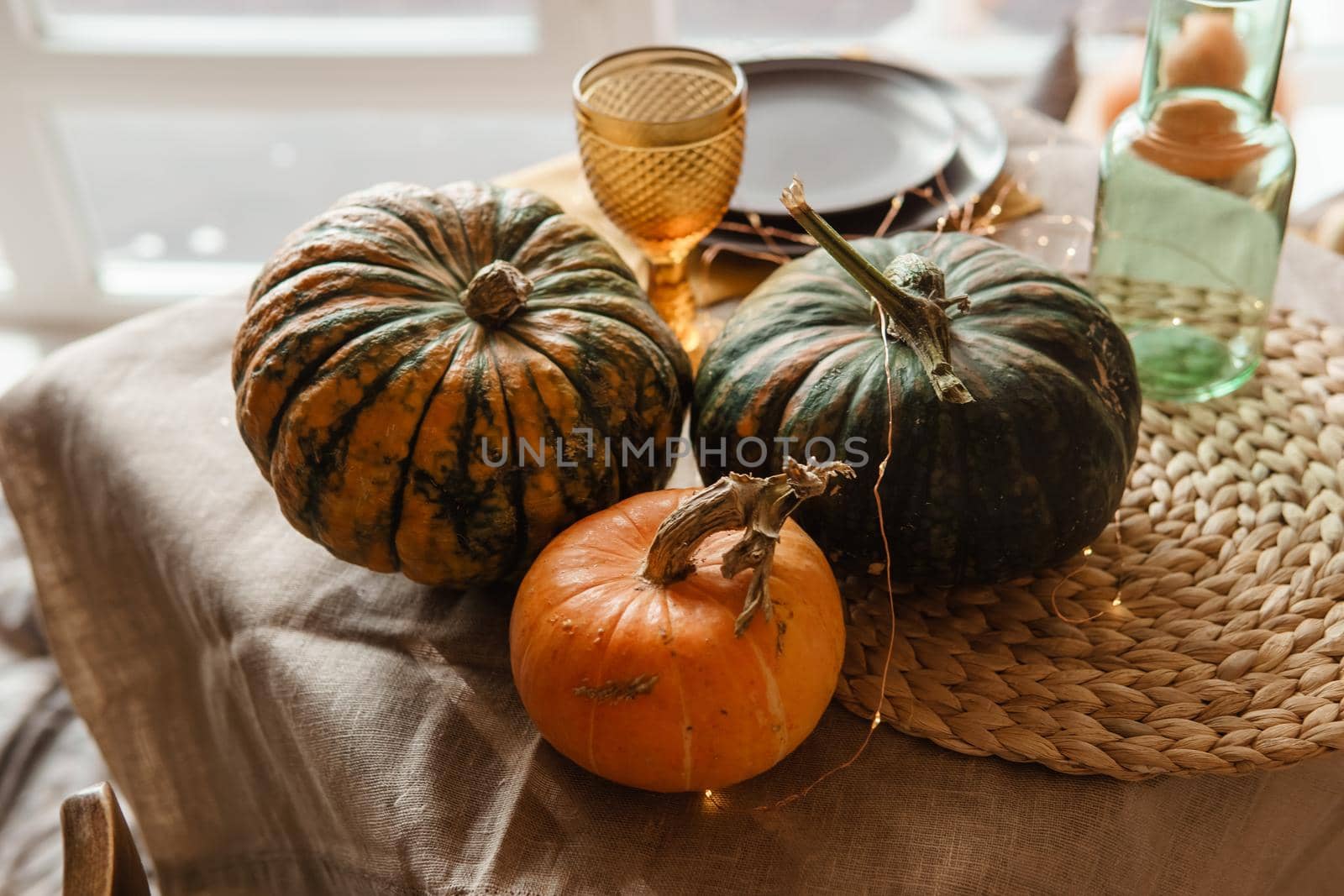 Autumn interior: a table covered with dishes, pumpkins, a relaxed composition of Japanese pampas grass. Interior in the photo Studio. Close - up of a decorated autumn table.