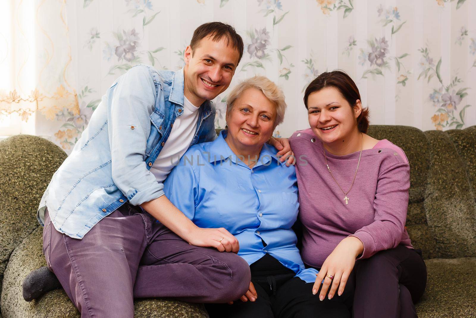 Grown up adult smiling grandchildren embraces elderly grandmother glad to see missing her, visit of loving relatives enjoy communication, cuddle as symbol of connection, love and support concept