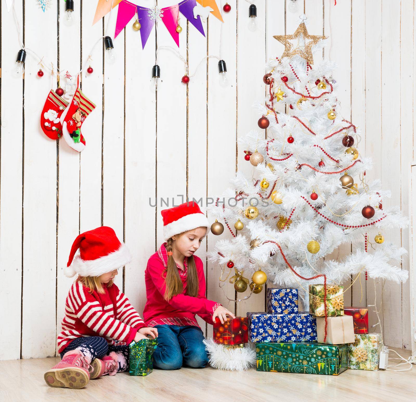 two little girls open christmas presents sitting on the floor by GekaSkr