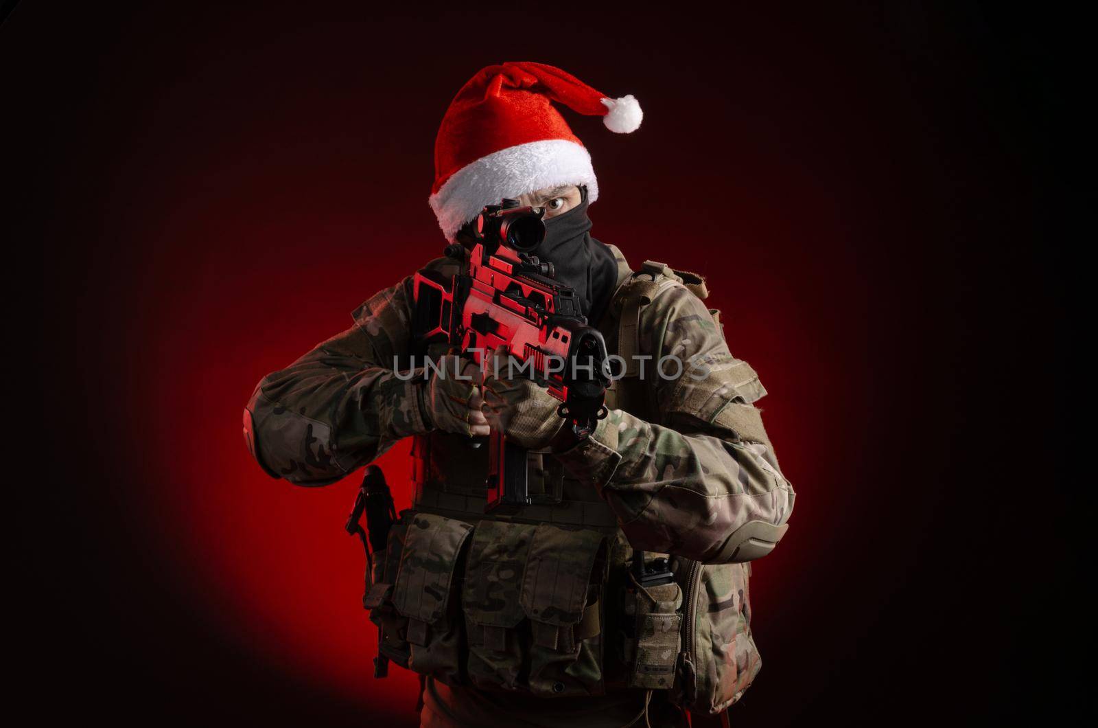 the man in a military uniform with a gun and a Santa Claus hat