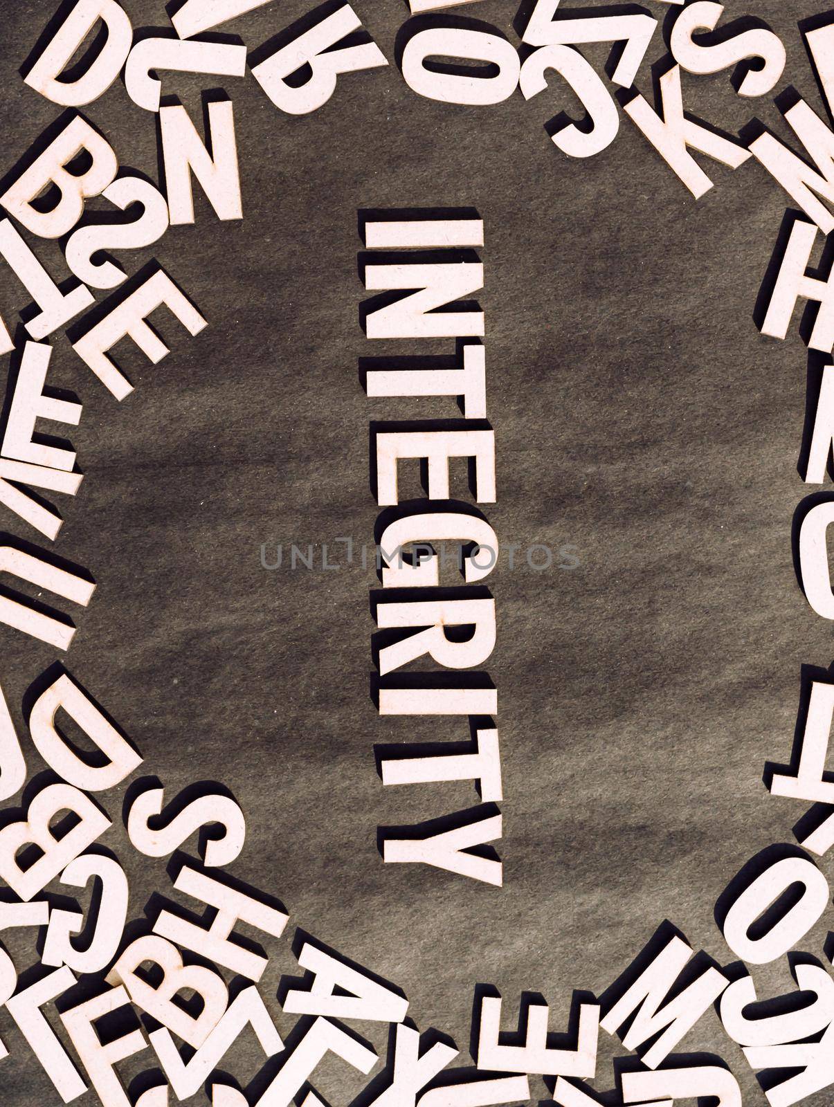 Integrity Word In Wooden Cube Alphabet Letters Top View On A rustic paper Background.