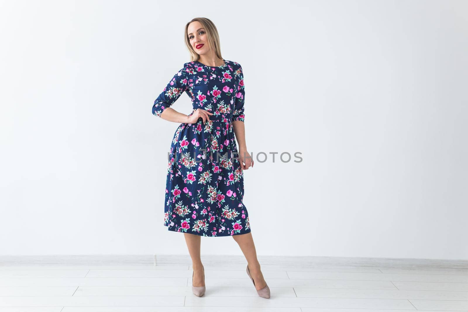 Fashionable young woman in beautiful dress posing at studio. Isolated over white.