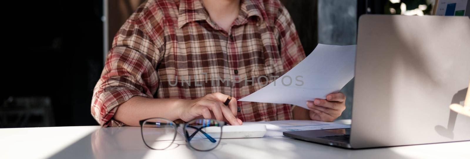 woman accountant financier working audit and calculating expense financial annual report balance sheet statement, doing finance checking document and making notes on report paper.