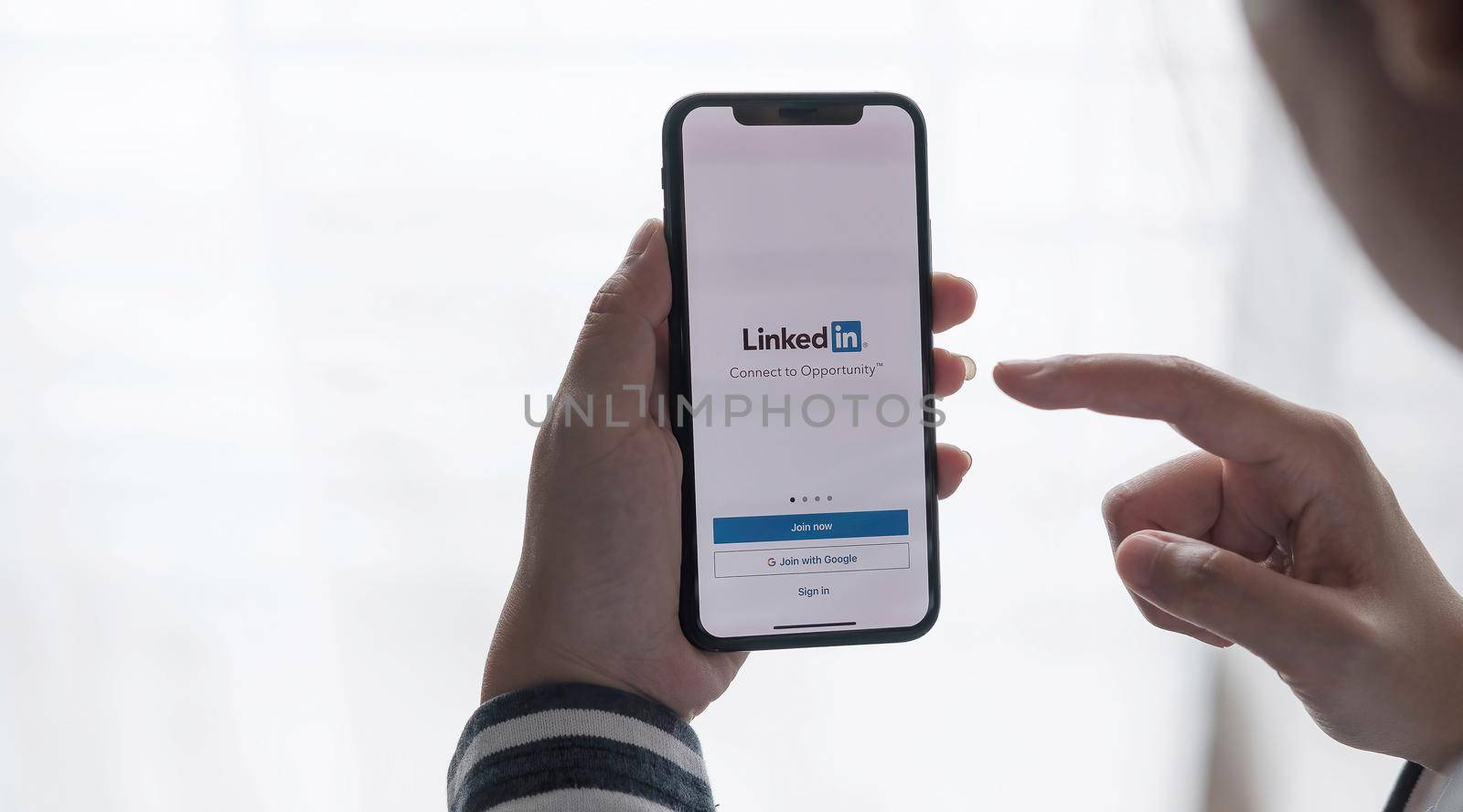 CHIANG MAI, THAILAND, JUL C12, 2021 : A women holds Apple iPhone Xs with LinkedIn application on the screen.LinkedIn is a photo-sharing app for smartphones. by wichayada