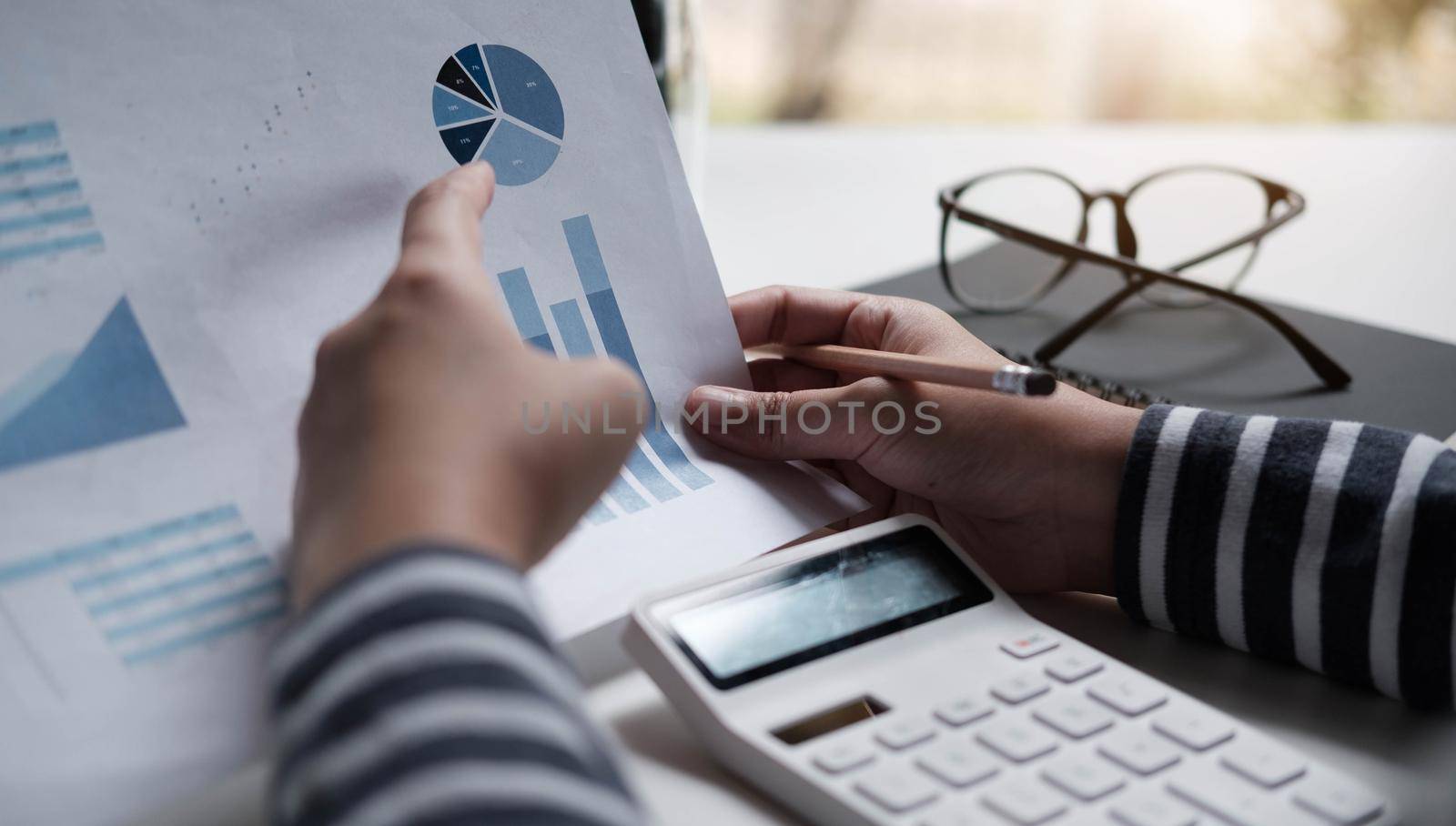 Business women reviewing data in financial charts and graphs by wichayada