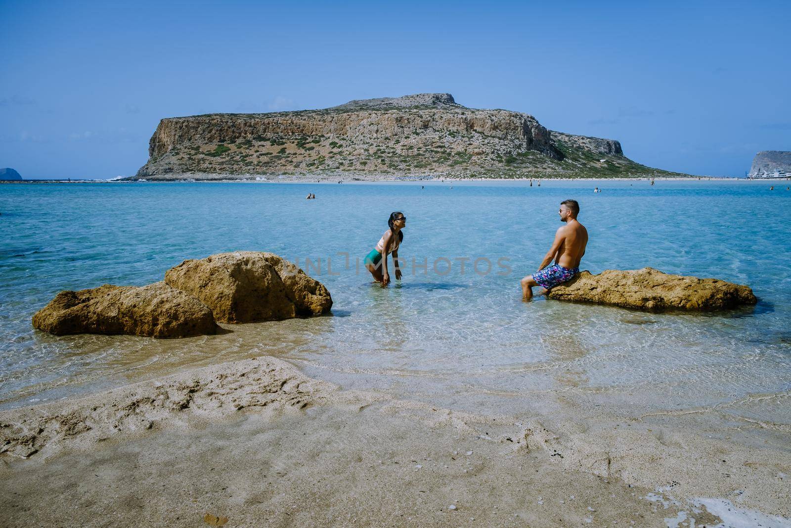 Crete Greece, Balos lagoon on Crete island, Greece. Tourists relax and bath in crystal clear water of Balos beach. Greece, couple men and woman visiting the beach