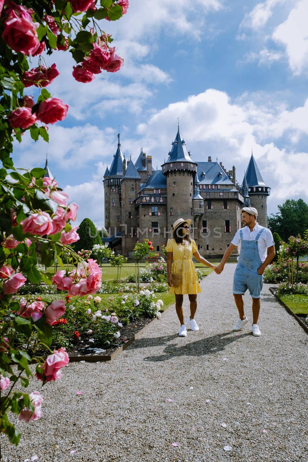 Castle de Haar Utrecht, couple men and woman mid age European and Asian visit De Haar Castle in Dutch Kasteel de Haar is located in Utrecht Netherlands during Spring with flowers in the garden