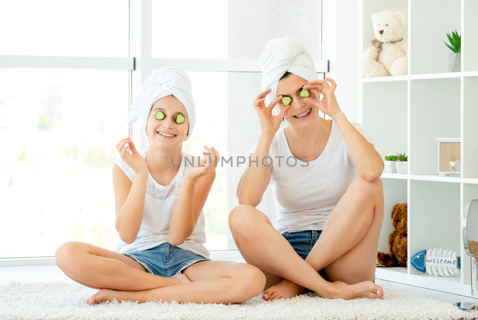 Young girl and her mother trying new cucumber mask by tan4ikk1