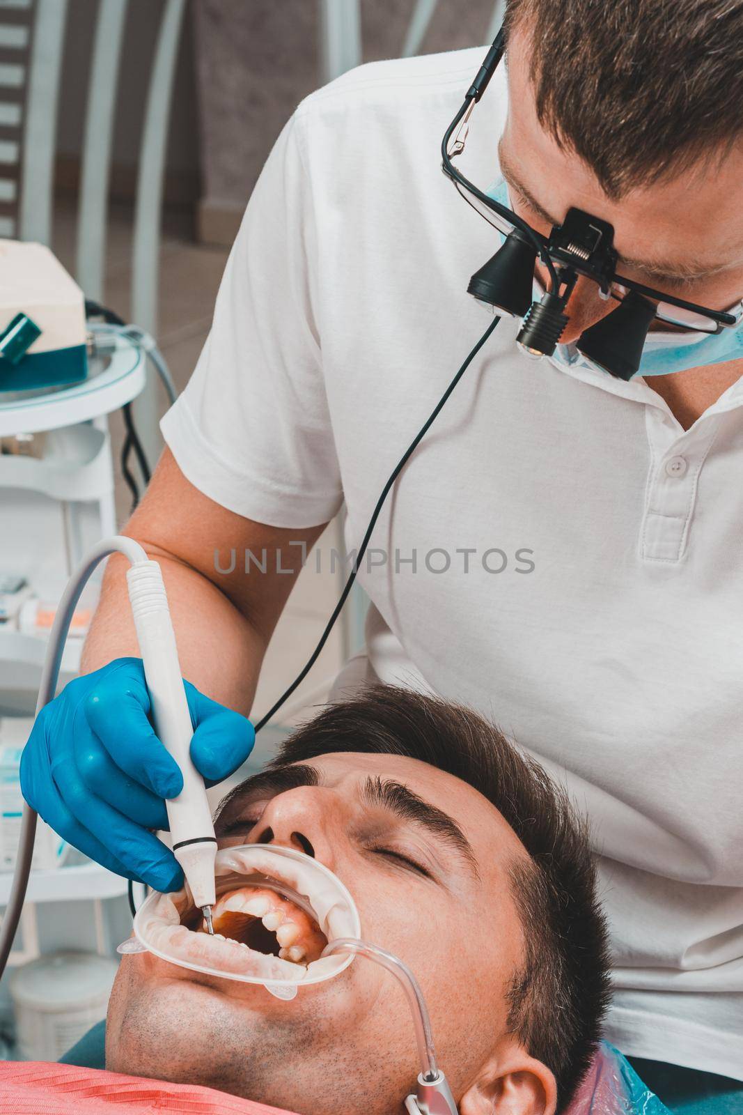 Dental clinic, private practice, the dentist uses binoculars for the best result and work, the process of removing tartar.2020
