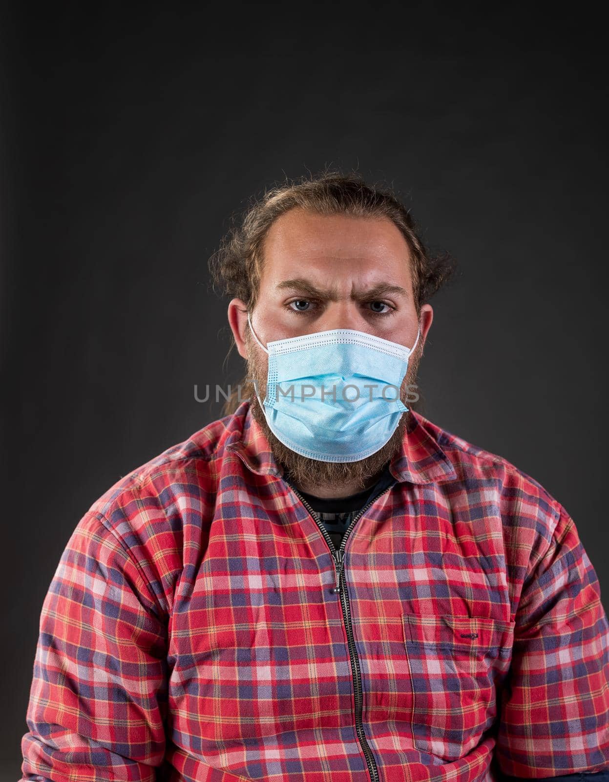 Portrait of angry man wearing facial mask as virus protection concept, shoot in studio