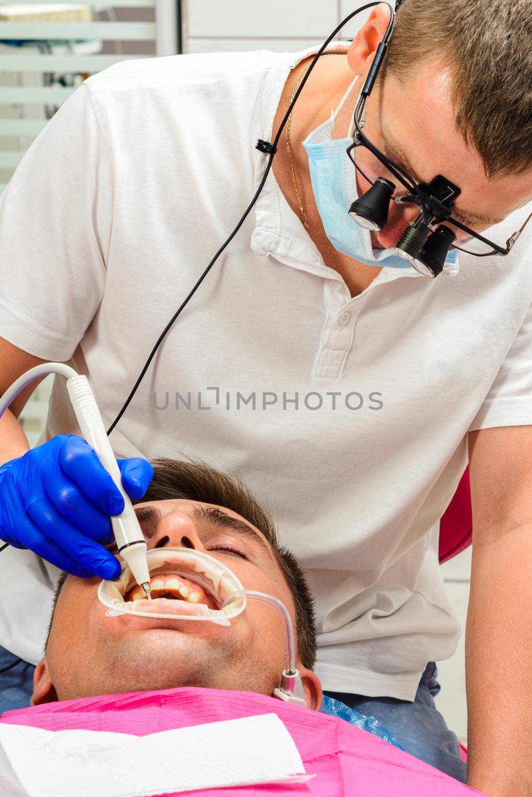 Dental clinic, private practice, the dentist uses binoculars for the best result and work, the process of removing tartar.2020