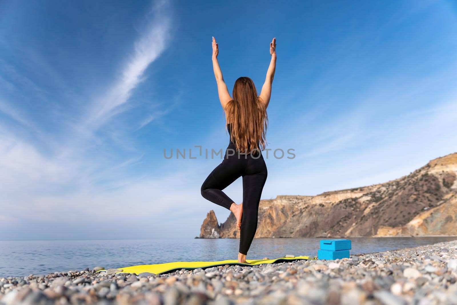 Group of young womans fitness instructor in Sportswear Leggings and Tops, stretching in the gym before pilates, on a yoga mat near the large window on a sunny day, female fitness yoga routine concept.
