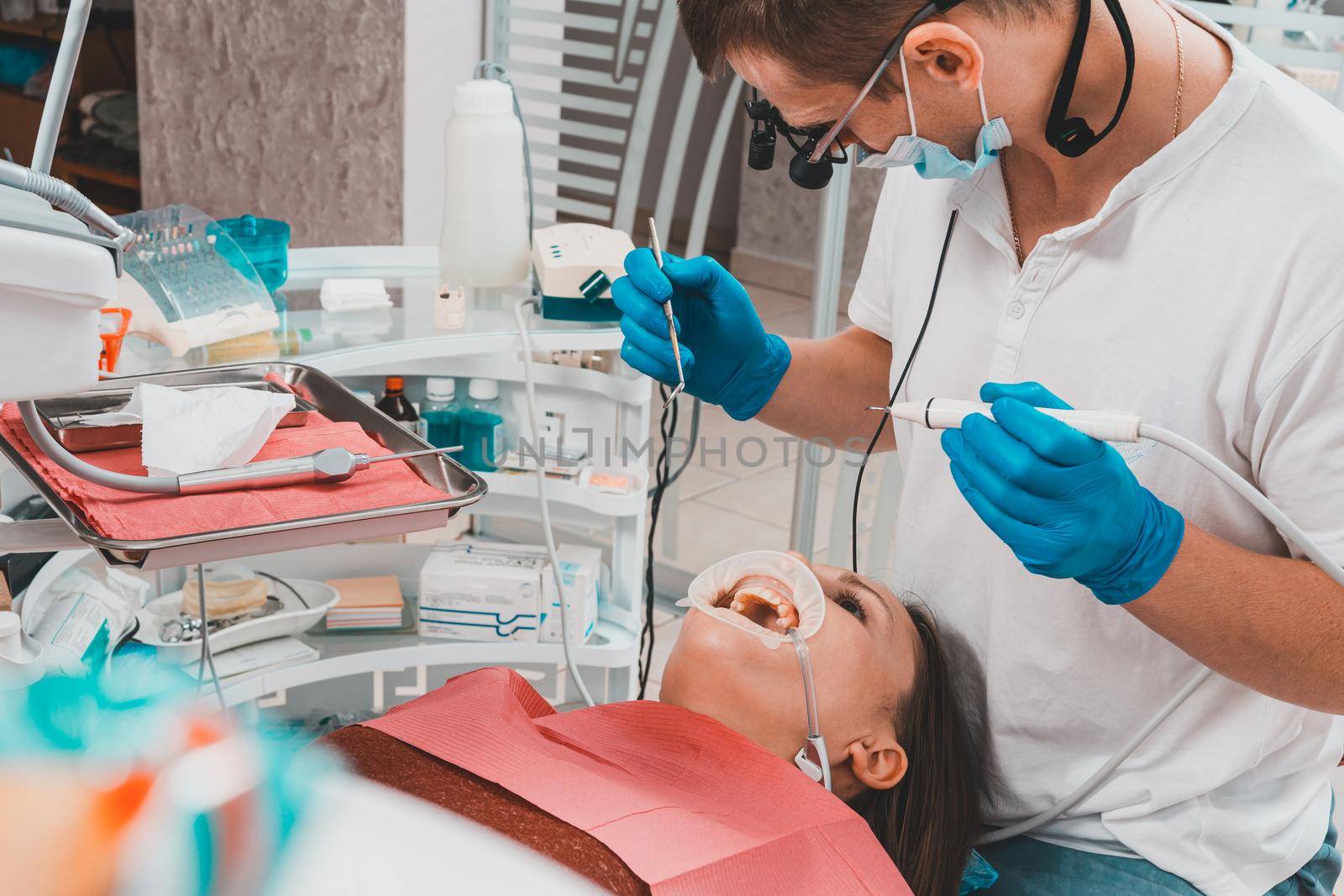 The dentist uses a scaler to remove tartar, oral hygiene. by Niko_Cingaryuk