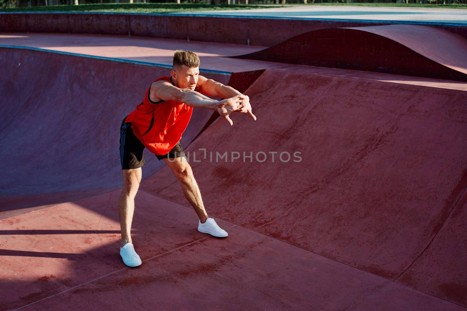 sports man doing exercises on the sports field fitness by Vichizh