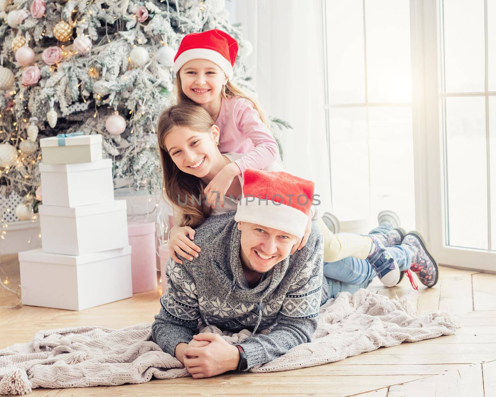 Happy family lying together near christmas tree