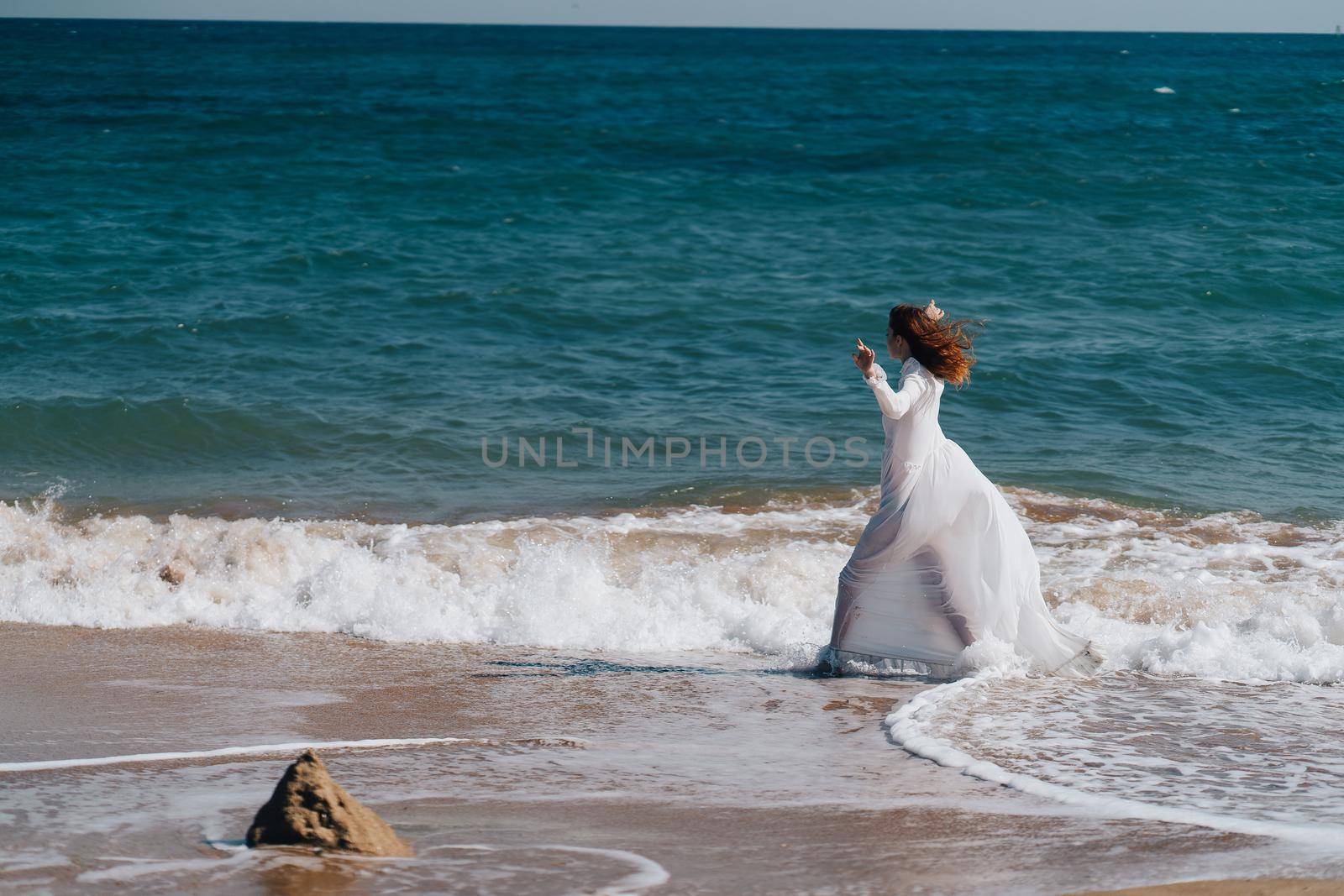 Woman in white dress freedom walk on ocean island. High quality photo