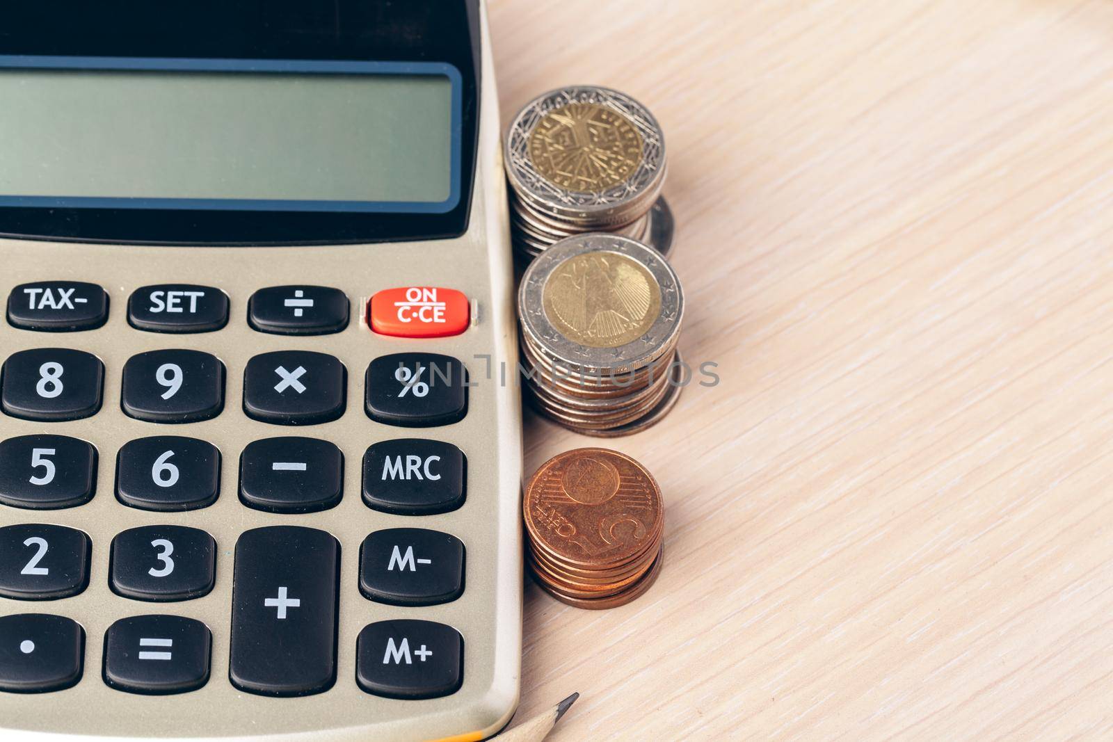 Close up of a calculator and coins on a business background