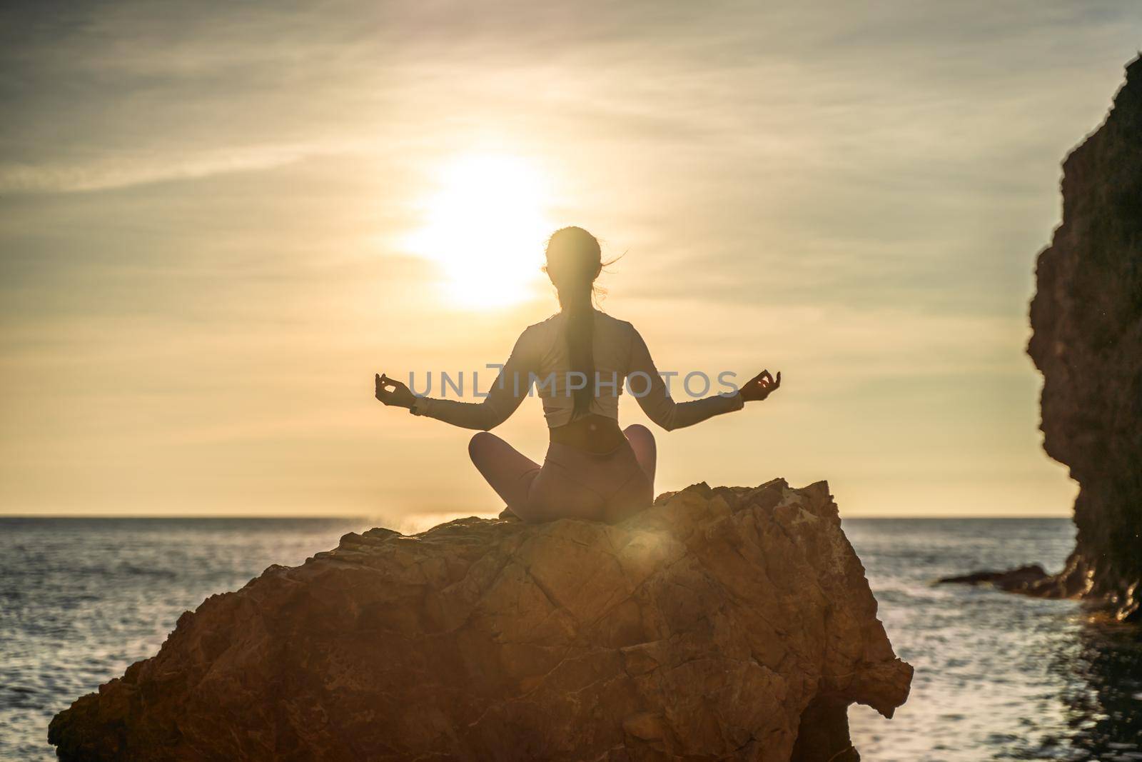 Young woman practicing yoga outdoors. Harmony and meditation concept. Healthy lifestyle.