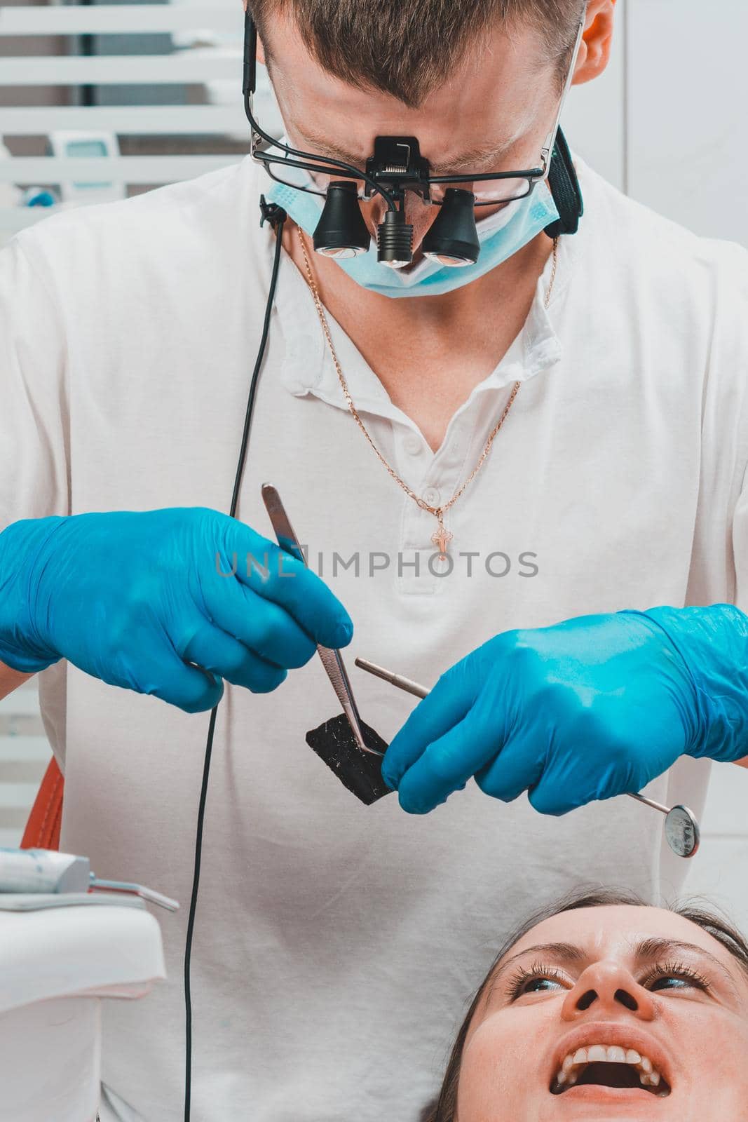 After filling, the dentist removes the excess material from the tooth with a copying tracing paper. by Niko_Cingaryuk