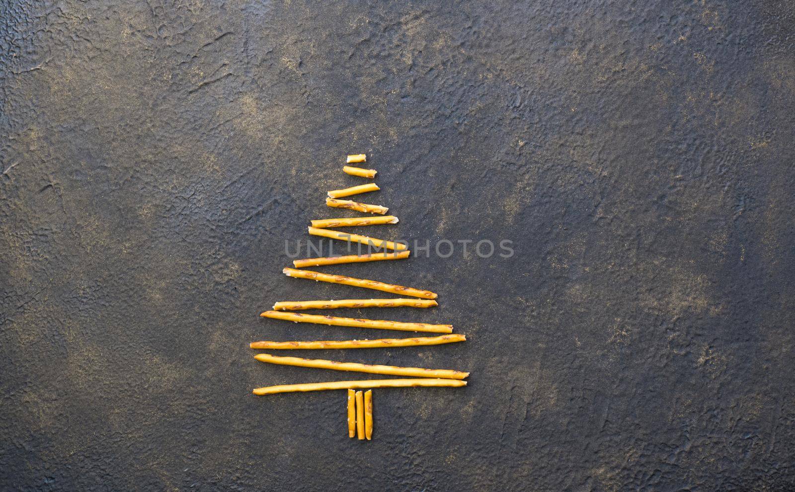 Christmas tree made from pepero straws cookies, on black texture background. View from above. by Ekaterina34