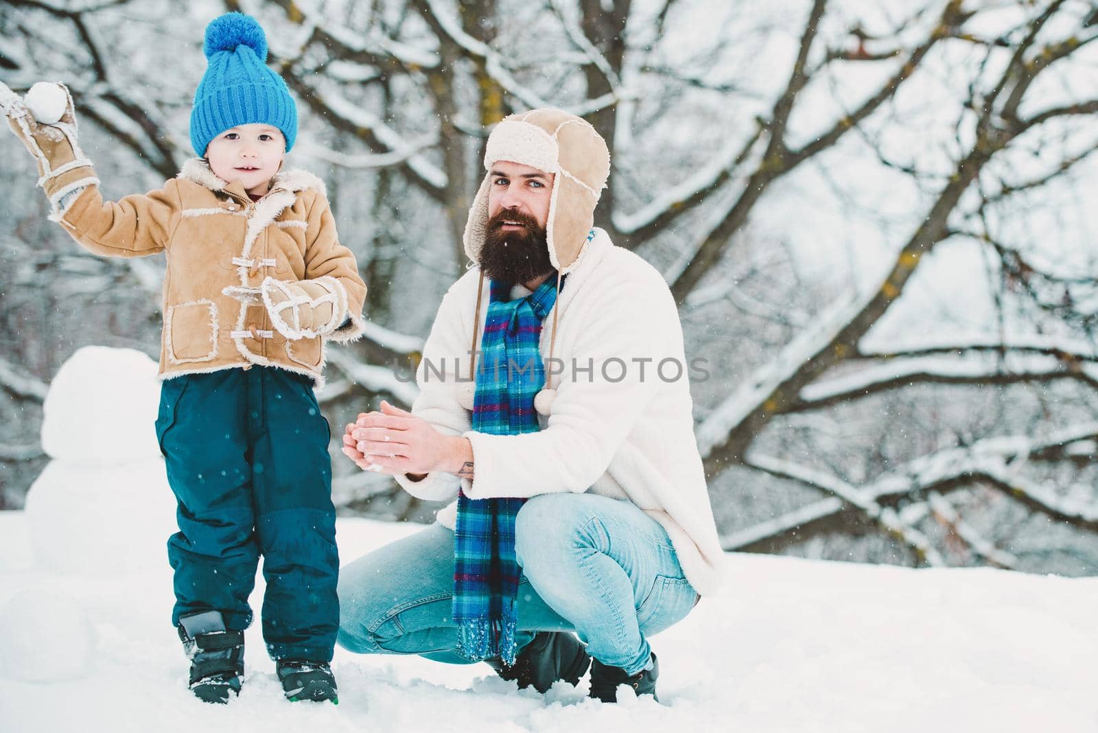 Winter, father and son play outdoor. Happy dad and child play on winter. Christmas time. Happy child playing with snowball against white winter background. Happy loving family