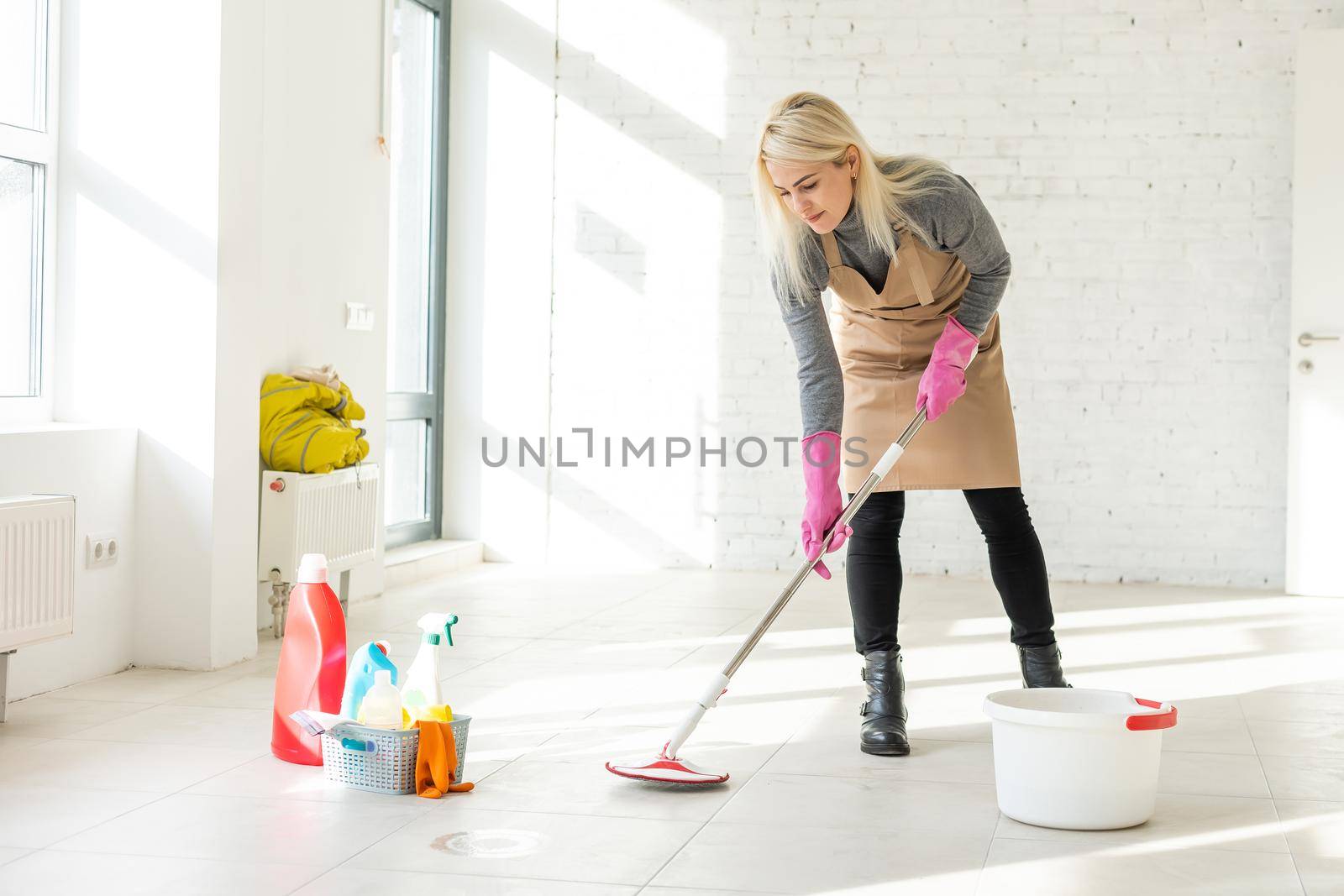 Professional janitor cleaning baseboard after renovation.